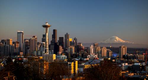Seattle with a mountain in the background.
                   The mountain has snow on it.
                   A building, which might be a UFO, is in the foreground.
                   Picture CC-BY tiffany98101.